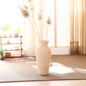 Large rattan floor vase with dried reed flowers, natural woven basket for home decor and display.