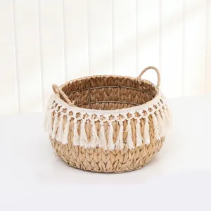 Handwoven straw storage basket detail with white fringe and double handles for home.