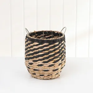 Handwoven storage basket detail view, black and natural straw woven utility bin with handles