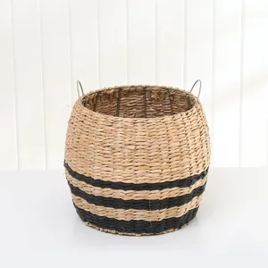 Handmade woven seagrass storage basket detail with metal handles and black striped design.