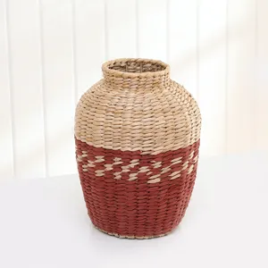 Close-up view of a handmade straw woven vase showing detailed two-tone texture and craft.