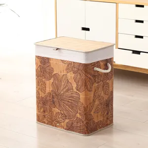 Detalle de cesta de ropa de bambú con textura tejida, patrón floral, tapa y asa de cuerda.