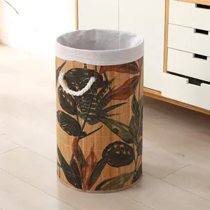 Cesta para ropa plegable de bambú con estampado tropical, asas de cuerda y forro de tela.