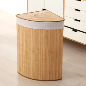 Cesto de ropa esquinero de bambú con tapa y asa de cuerda para almacenamiento en casa.