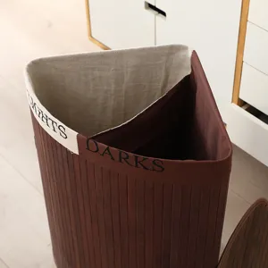 Primer plano detallado de la cesta de ropa de bambú con doble compartimento y etiquetas.
