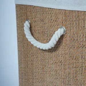Close-up detail of woven bamboo laundry basket with white rope handle and fabric lining.