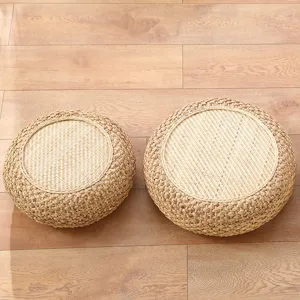 Detail shot of round straw meditation cushion, natural woven texture, thick tatami pouf.