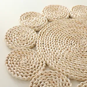 Close-up of handmade straw braided heat insulation placemat with natural pastoral floral design.