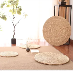 Natural straw woven round cushion detail, textured handmade tatami meditation floor mat.
