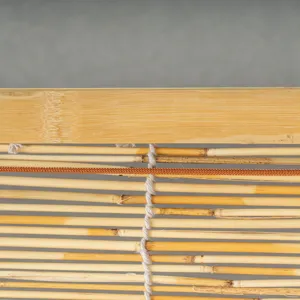 Close-up detail of natural reed blind texture, showing weaving craftsmanship and durable wooden top.