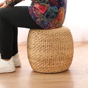 Detailed shot of a natural straw woven pouf stool used in a cozy tatami living room setting.