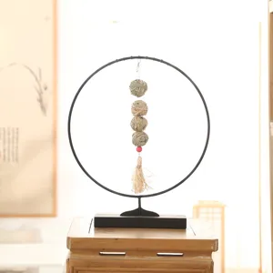 Detailed view of parrot chewing ball and hamster molar hanging toy on metal stand with grass balls.