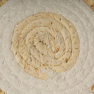 Close-up detail of hand-woven corn husk and cotton rope placemat showing texture.