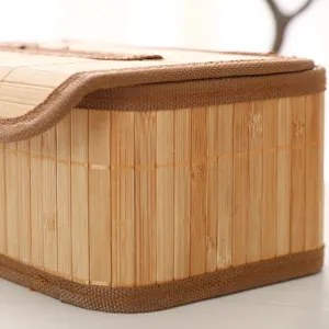 Gedetailleerd close-up van een handgemaakte bamboe tissuebox met duurzame stoffen rand.