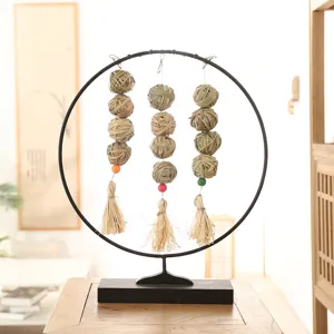 Detailed close-up view of natural wicker bird chewing toy hanging on a sleek metal ring stand.