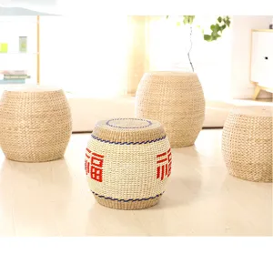 Detail view of handmade woven straw pouf with traditional fortune character accent for home decor.
