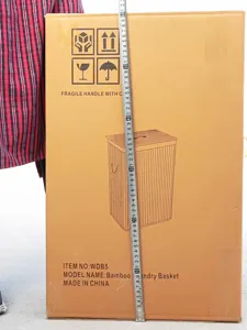 Packaging detail showing the size and model of the bamboo laundry basket with tape measure.
