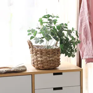 Nordic handmade woven straw flower basket with artificial eucalyptus plant for home decor.