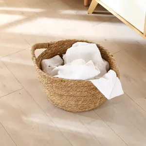 Handmade woven straw storage basket for laundry and home organization, natural round design detail.
