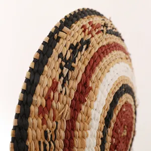 Close-up detail of natural woven straw wall hanging showing intricate concentric pattern.