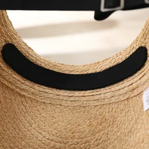 Straw sun visor detail view showing raffia braid texture, sweat pad and adjustable strap.