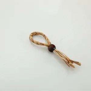 Handmade woven paper napkin ring with wooden bead and tassel, rustic table decor for dining.