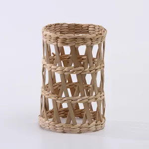 Detailed shot of natural straw woven cylinder cup sleeve texture and hollow design pattern
