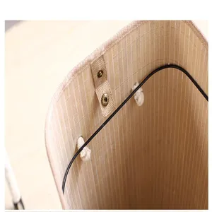 Detalle en primer plano que destaca el marco metálico interior y el botón de presión de la cesta.