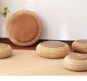 Round straw woven meditation cushion with brown seat, thick tatami floor pouf for home decor.