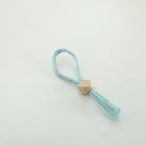 Light blue woven paper napkin ring with a wooden hexagonal bead, simple tabletop decor item for dining.