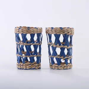 Handmade straw woven cup sleeve, blue and natural color geometric open mesh design detail.