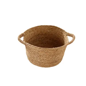 Handmade straw woven storage basket with handles for laundry and home organization.