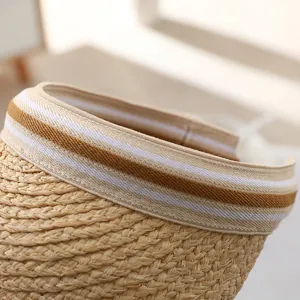 Detail shot of summer straw sun visor, handmade woven texture and striped elastic band.