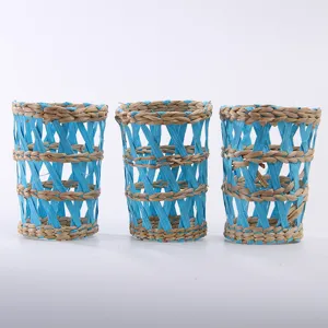 Detailed view of handmade woven straw cup sleeves, blue and natural brown design, exquisite texture.