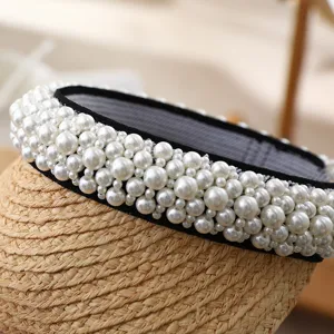 Handmade pearl straw sun visor hat detail shot, elegant summer beach headwear accessory.