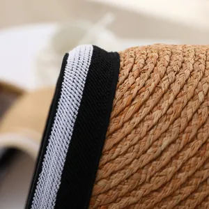 Close-up detail of a handmade summer straw sun visor hat with stylish black white trim.