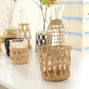Handcrafted straw woven cup sleeves and glass bottle covers for rustic home decor and styling.
