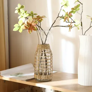 Close-up detail of a creative glass vase wrapped in natural straw woven sleeve for home decor.