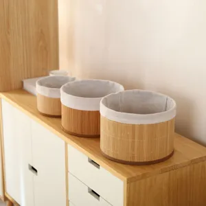 Close-up view of round woven storage baskets with fabric lining on wooden cabinet.