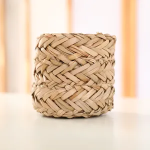 Close-up detail of natural woven straw plant pot cover, showing tight texture and craft.