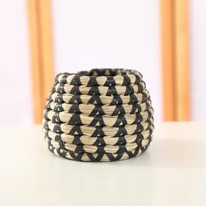 Close-up view of the hand-woven seagrass basket and planter, showing detailed black and natural texture.