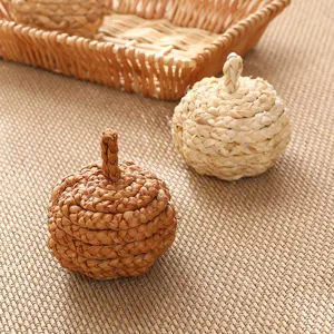 Handmade straw woven pumpkin decor craft, natural rustic tabletop ornament, close-up detail.