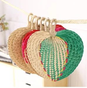 Handmade woven palm leaf fan detail, natural straw material, traditional rustic style hanging decor.
