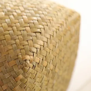 Close up detail shot of handmade woven natural straw storage basket texture pattern corner.