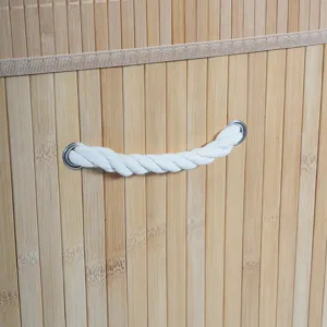 Detalle de cesta de lavandería de bambú con textura y asa de cuerda, almacenamiento.