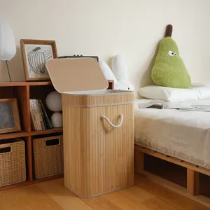 Vista detallada del cesto de ropa de bambú con tapa y asas de cuerda en dormitorio acogedor.