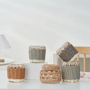 Nahaufnahme handgemachter Rattanglasbecher und Vorratsglas mit feiner Geflechtstruktur Szene.