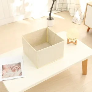 Foldable fabric storage basket, beige non-woven clothes organizer box for home wardrobe and desktop.