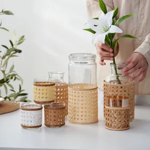 Handmade rattan woven glass vase detail shot showing exquisite braided texture and natural aesthetic.