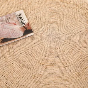 Handcrafted round woven jute straw rug detail, natural plant fiber floor mat texture close up